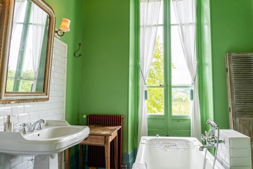 A bathroom with a bathtub and garden views