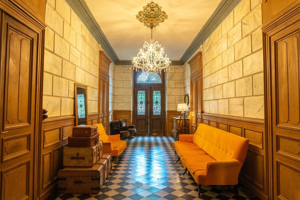 The grand hallway with its chequered floor and chandelier